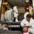Person wearing protective coveralls sitting in front of a truck reviewing a work order.
