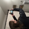 Person holding up a thermal imaging camera to an exhaust fan.